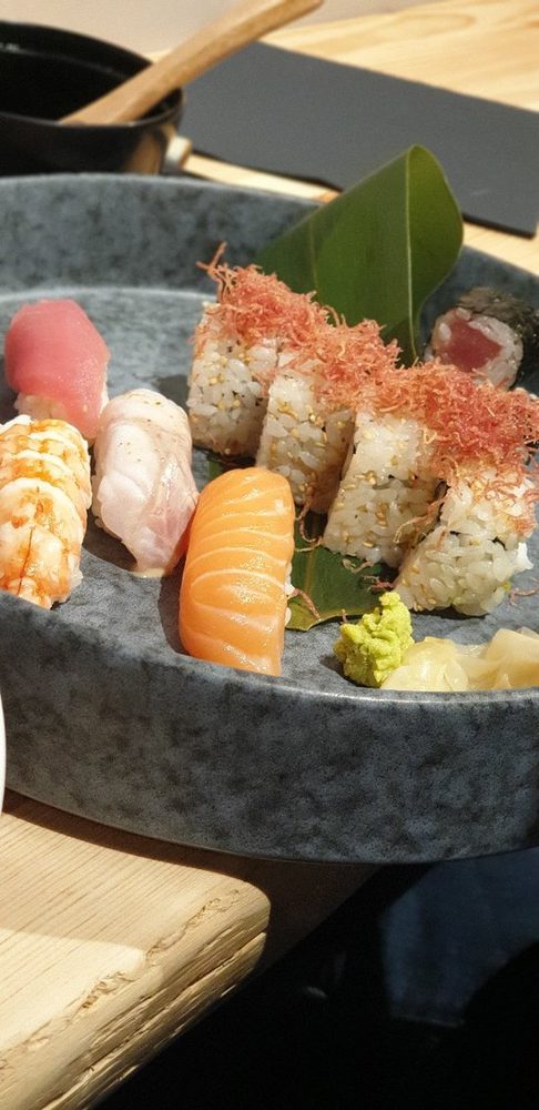 Nigiri di salmone, tonno, ricciola e gambero in una ciotola di pietra.